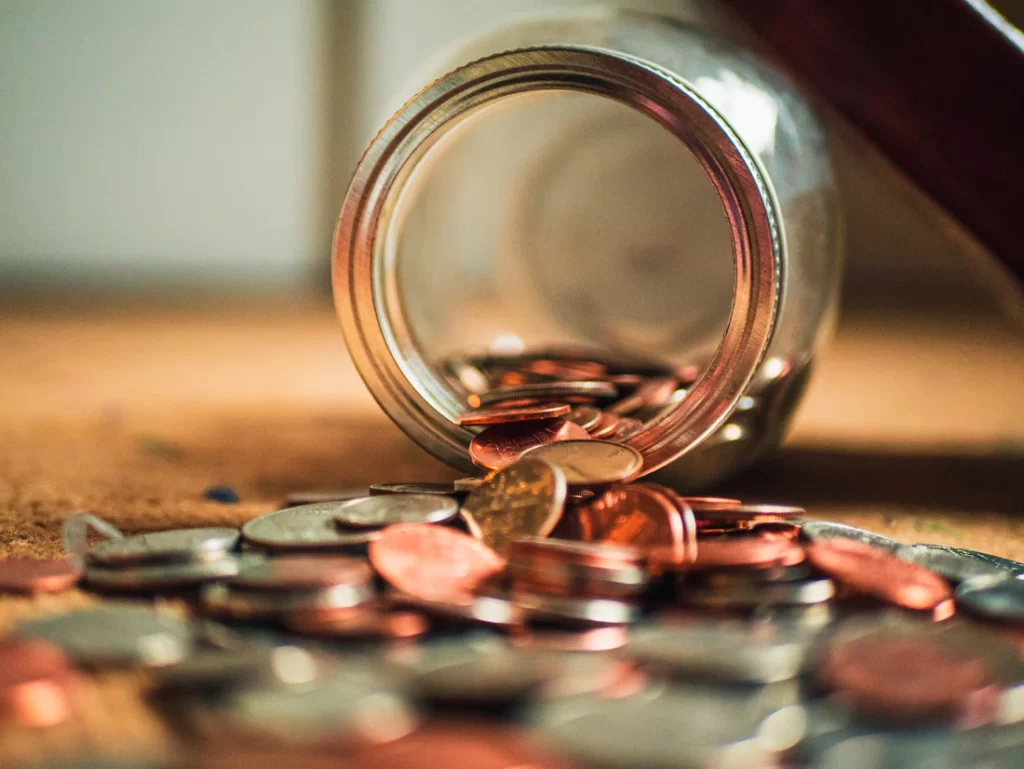 Money falling out of a glass jar